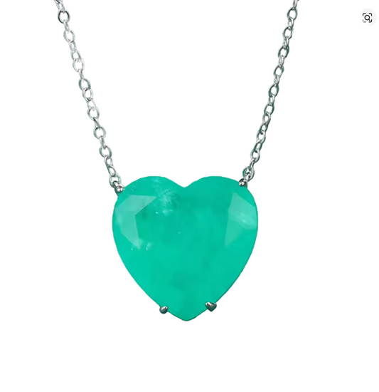 A heart-shaped green gemstone pendant necklace on a silver chain, set against a dark green textured background.