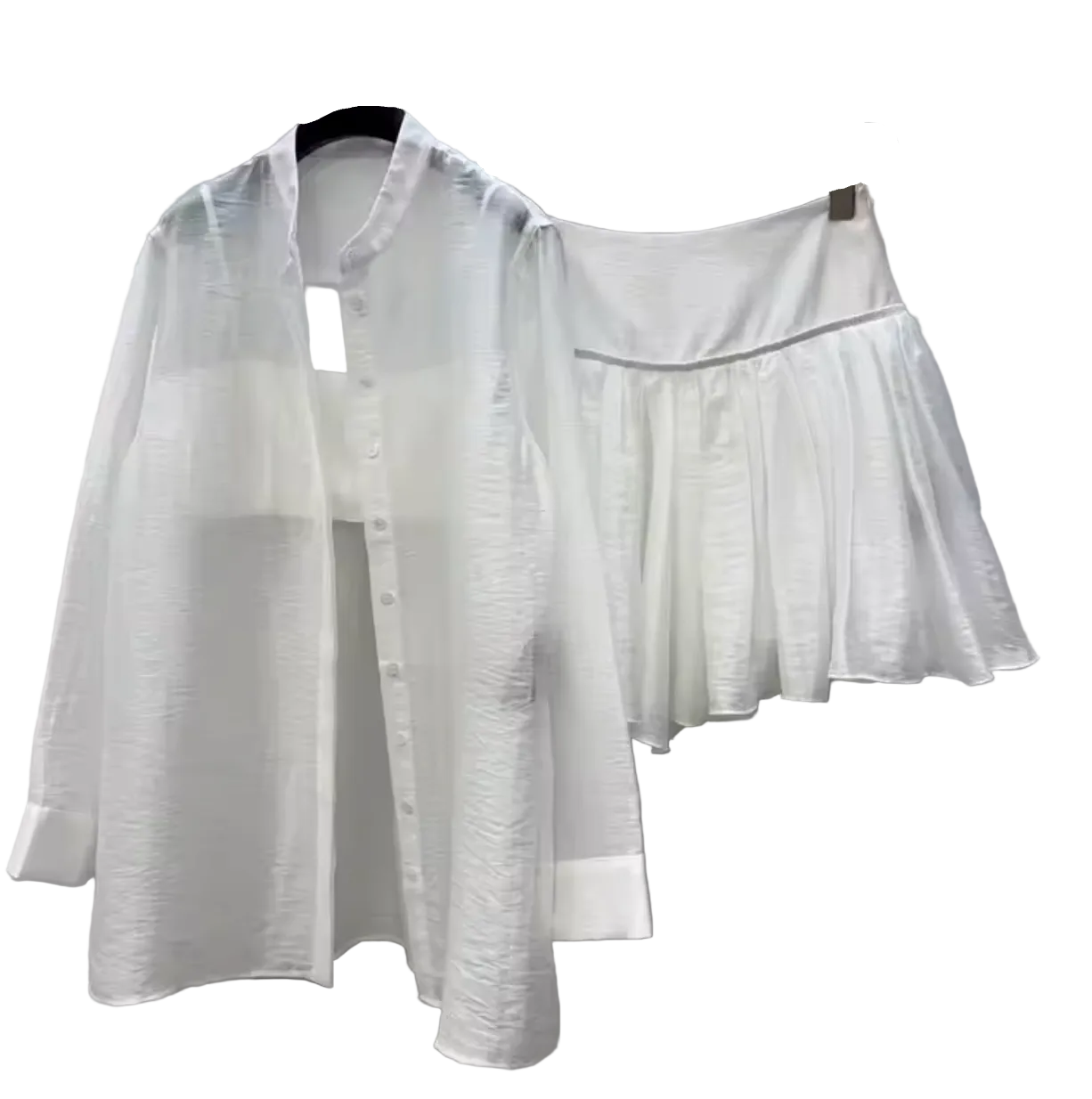 A white long-sleeve button-front shirt and a matching white pleated mini skirt hanging on black hangers against a light gray paneled wall.