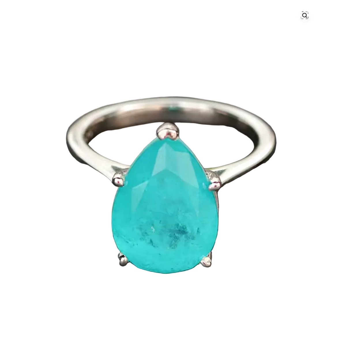 A silver ring featuring a large, faceted pear-shaped turquoise gemstone in a four-prong setting, displayed on a dark textured background.
