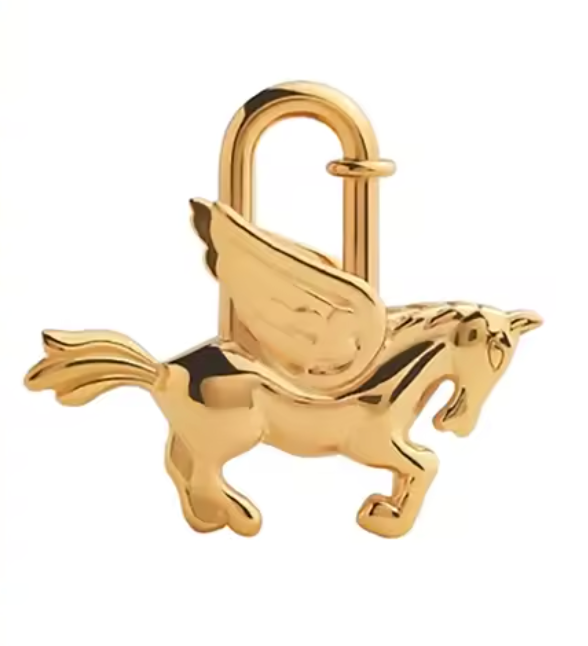 A shiny gold winged horse charm shaped like a Pegasus, isolated on a white background in brass. 