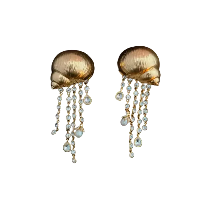A pair of gold-toned shell-shaped drop earrings with dangling pearl-like beads, shown on a black background.