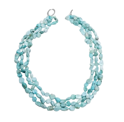 A multi-strand necklace made of light blue marbled stone beads with silver-toned clasp hardware, displayed on a textured white background.