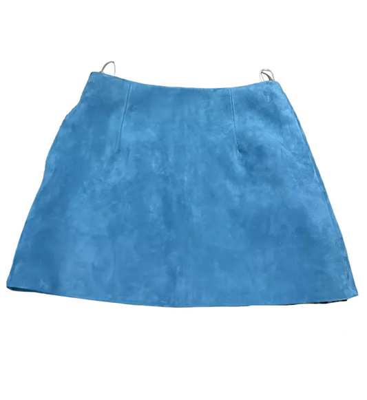 A bright blue suede mini skirt laid flat on top of leopard print and brown textured fabric pieces.